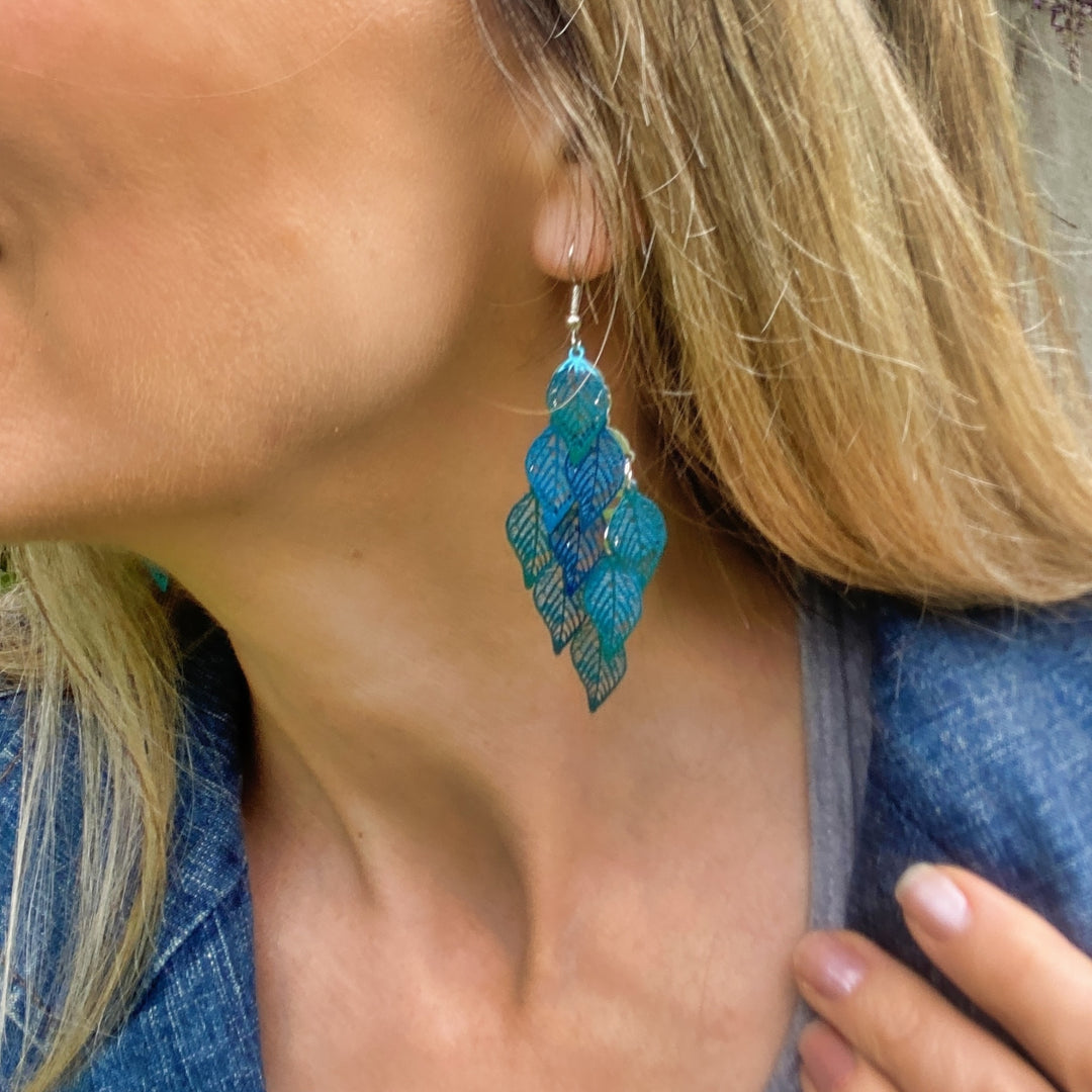 Blue statement earrings, layered leaf design, metallic shimmer finish, lightweight dangle style, bold and artistic accessory