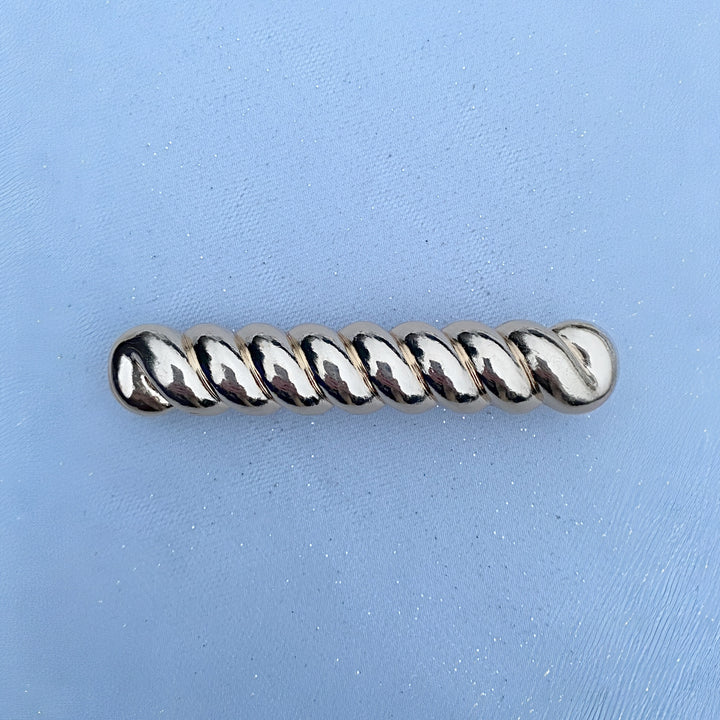 Gold barrette, large hair clip design, twisted metallic bar pattern, polished finish, secure clasp fastening, elegant decorative accessory, minimalist style