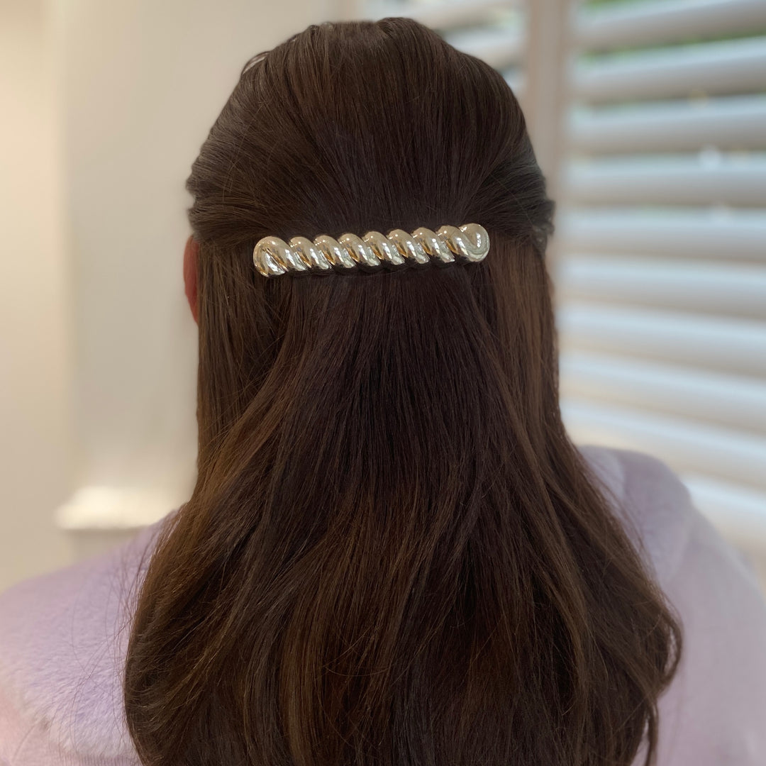 Silver hair barrette, large clip design, polished metallic finish, curved shape, strong clasp fastening, styled in half-up brunette hair, elegant decorative accessory