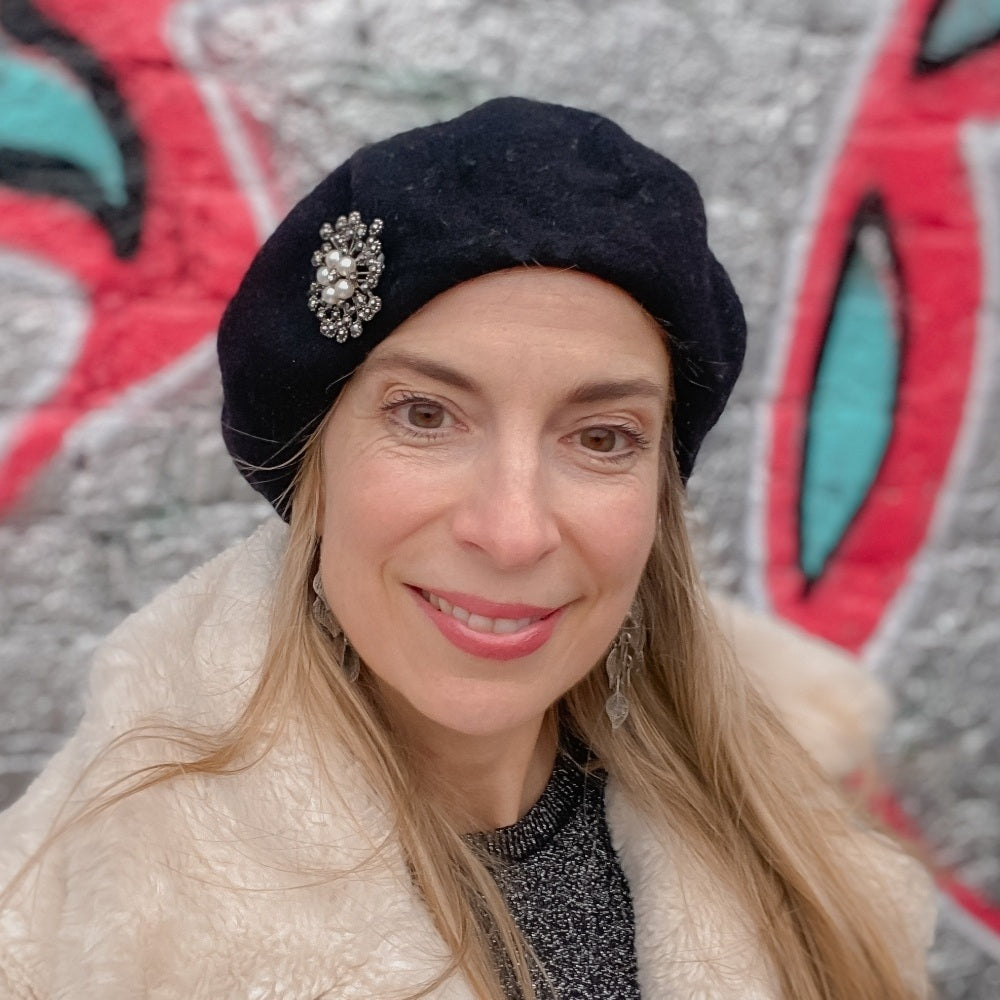 Silver-tone brooch with clear crystals and a central pearl in an ornate vintage-inspired design.