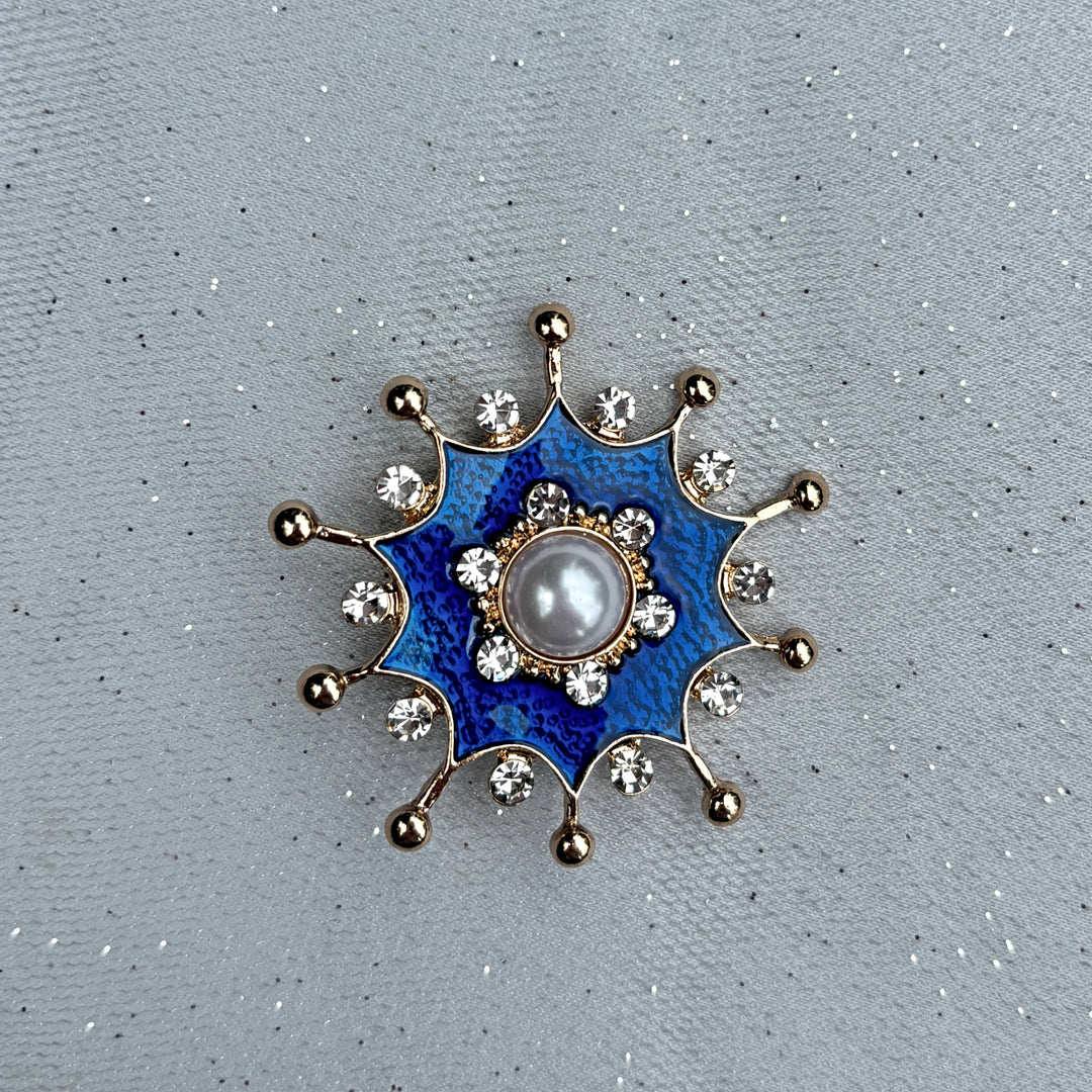 Blue pearl brooch, gold tone starburst design, central white faux pearl, deep blue enamel detailing, surrounded by clear crystal accents, vintage inspired jewellery, elegant statement accessory, unique gift for her
