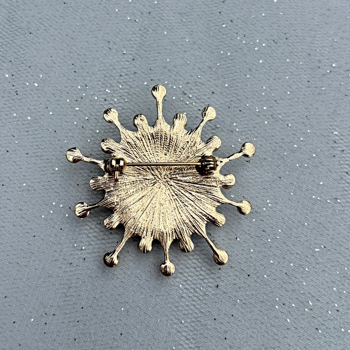 Gold starburst brooch, textured metal finish, radiating sunburst design, secure pin fastening, vintage inspired jewellery, bold statement accessory, elegant gift for her
