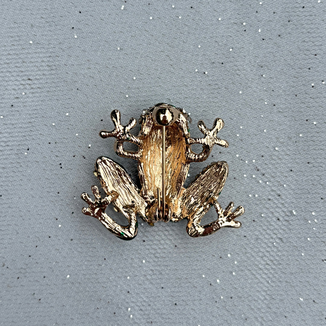 Frog brooch, gold tone metal, green enamel body, clear crystal diamante accents, playful animal design, vintage inspired jewellery, sparkling statement accessory, unique gift for her
