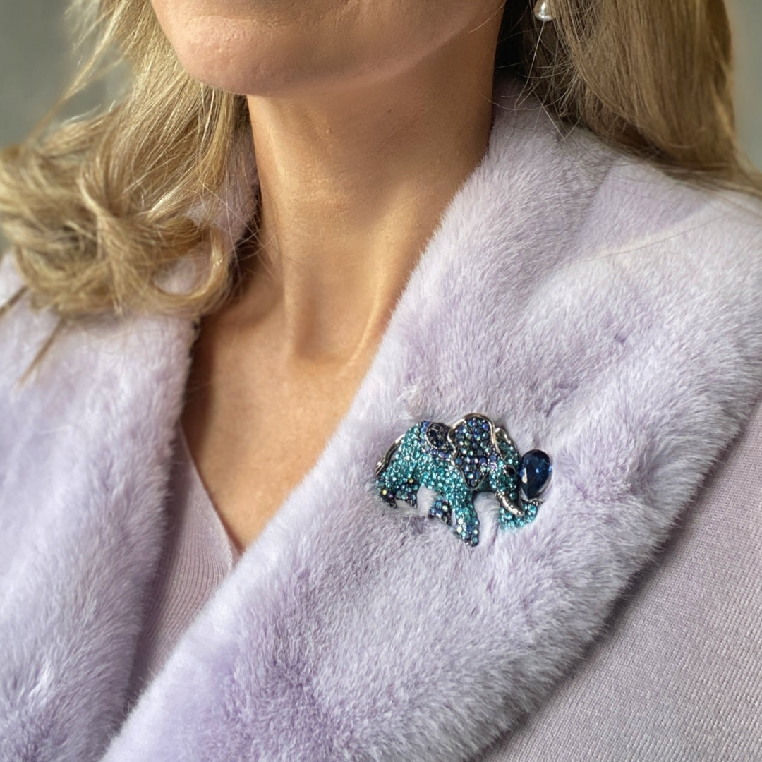 Blue crystal elephant brooch with a large dark blue teardrop stone.