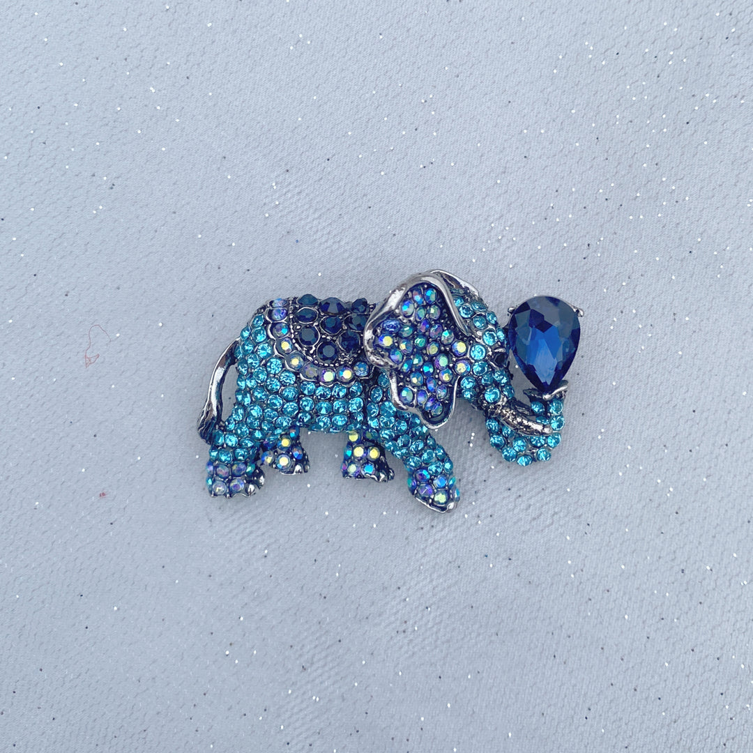 Blue crystal elephant brooch with a large dark blue teardrop stone.