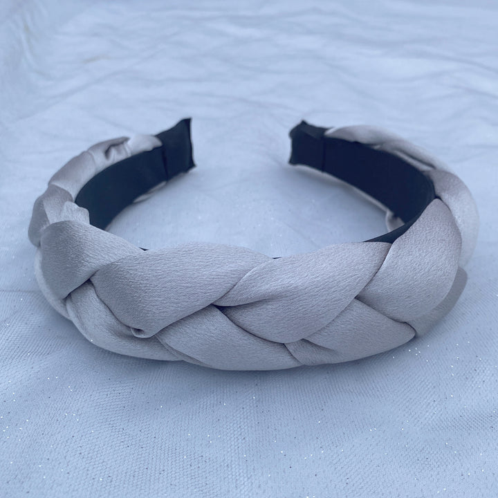Light grey satin braided headband with a soft, padded structure.
