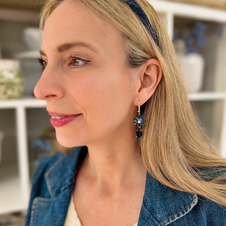 navy blue earrings flower drop earrings worn by a woman with a headband and denim jacket a daytime outfit