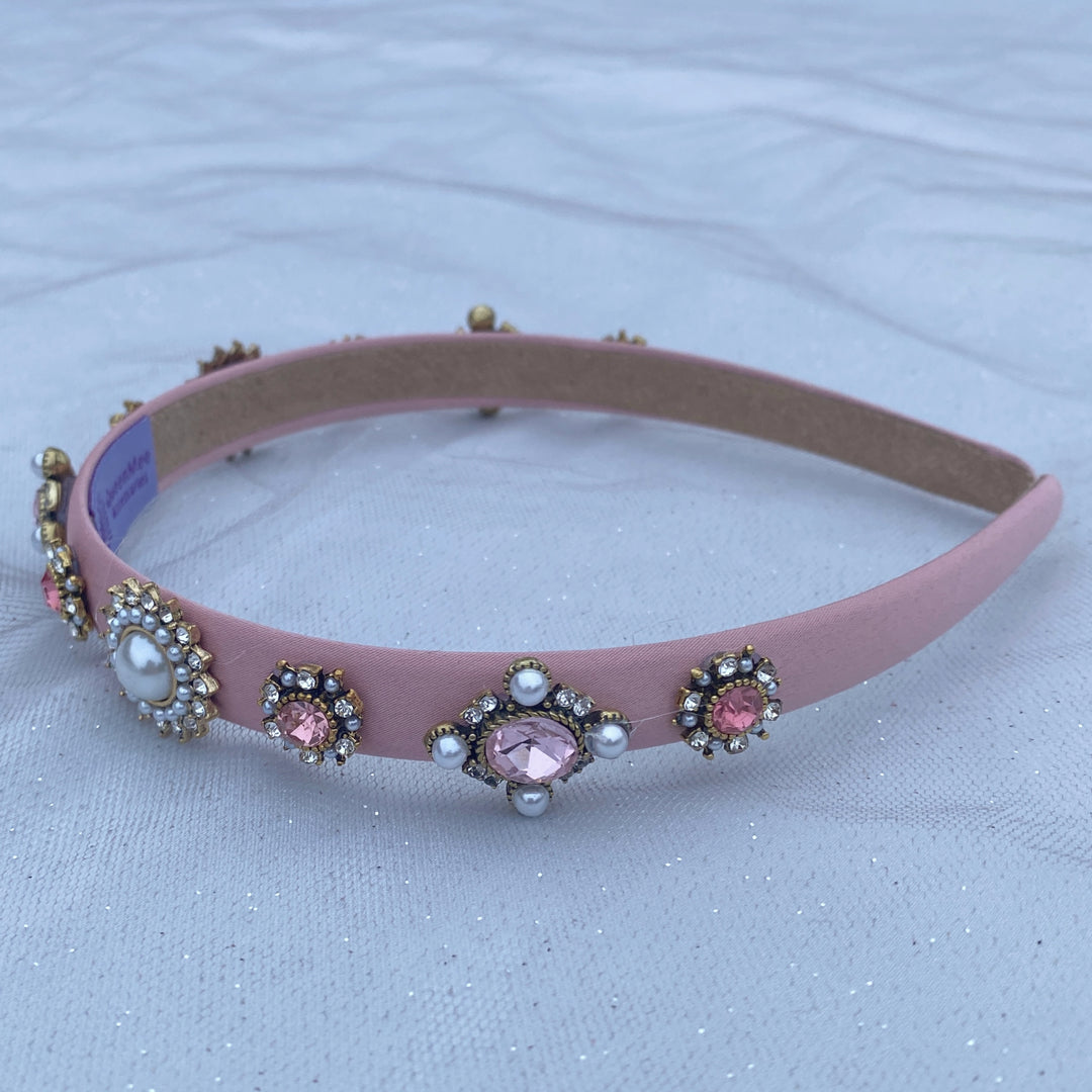 Pink headband decorated with pearl and crystal floral embellishments.
