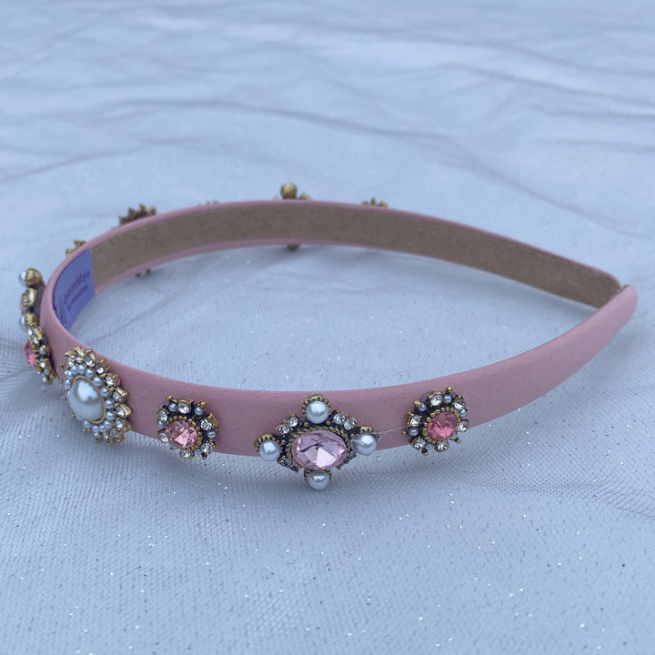 Pink headband decorated with pearl and crystal floral embellishments.