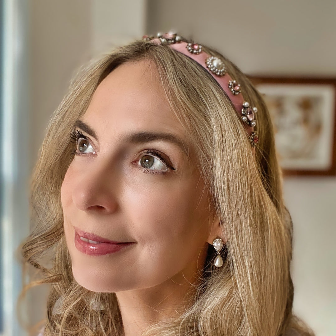 Pink headband decorated with pearl and crystal floral embellishments.
