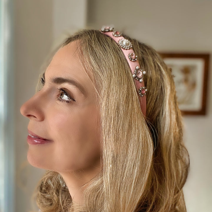 Pink headband decorated with pearl and crystal floral embellishments.