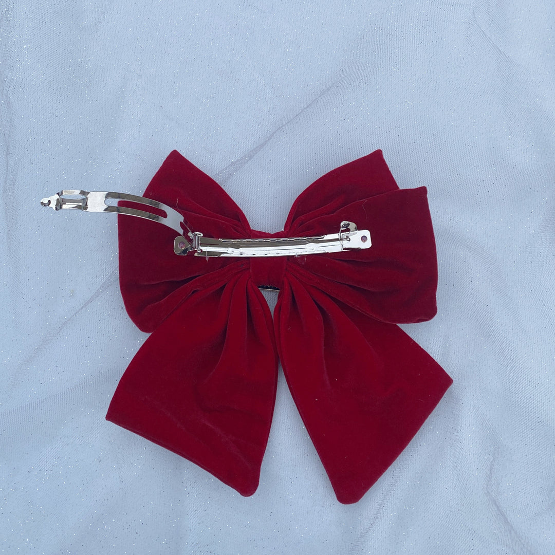 Large red velvet bow hair clip with a jeweled buckle detail.