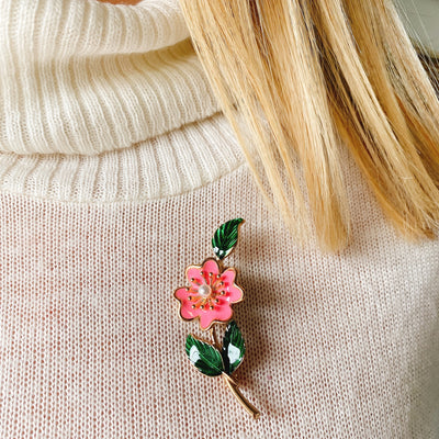 floral enamel pin in pink worn on jumper