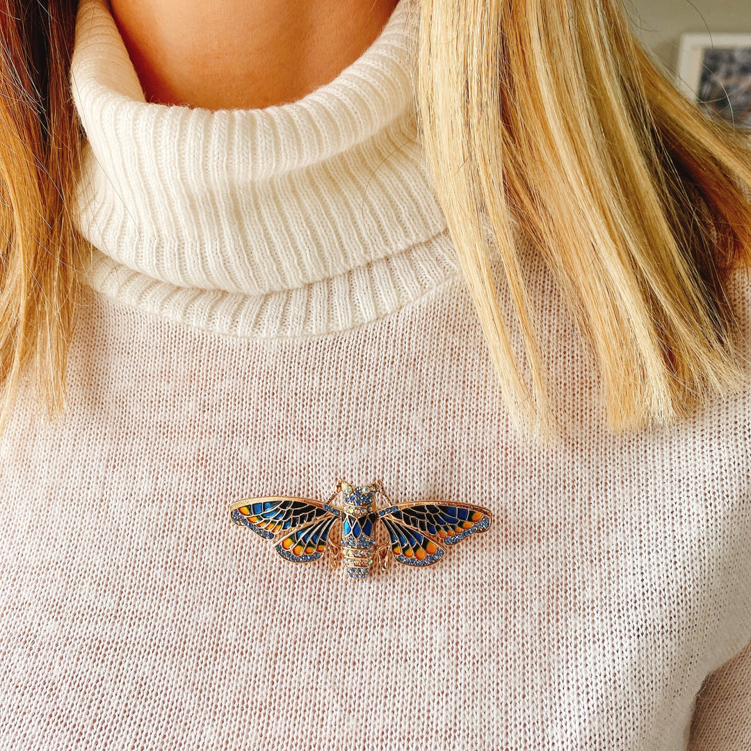 moth brooch in blue enamel worn on jumper