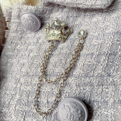 silver crown brooch with chain on jacket